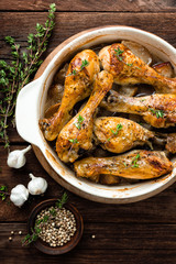 Roasted chicken legs on rustic wooden background, top view