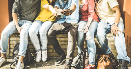 Group of multiculture friends using smartphone on urban background - Technology addiction concept in youth lifestyle disinterested to each other - Always connected people on modern mobile smart phones - obrazy, fototapety, plakaty