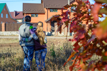 Rear view of young couple looking at their new house