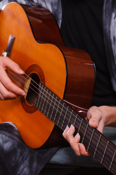 Closeup of man playing acoustic guitar
