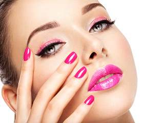 eautiful woman face with pink makeup of eyes and nails.