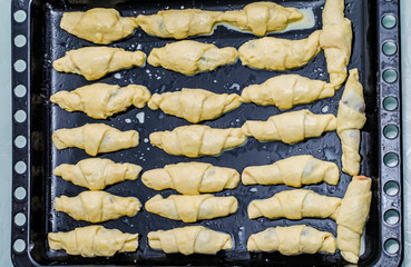 Girl makes homemade cinnamon buns, sliced rolls of dough roll. View from above, hands in picture
