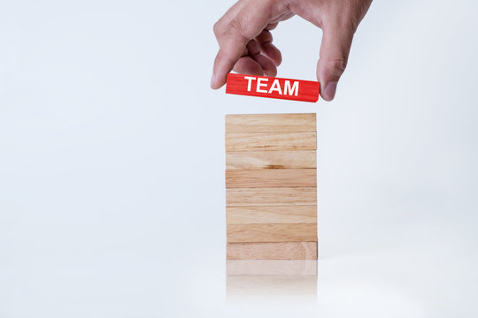 Business Man Holding Red Wood Block With Team Letter. Team Work