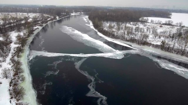Aerial View. Flight over the beautiful winter river and forest. Nature in winter. Landscape panorama. Ukraine