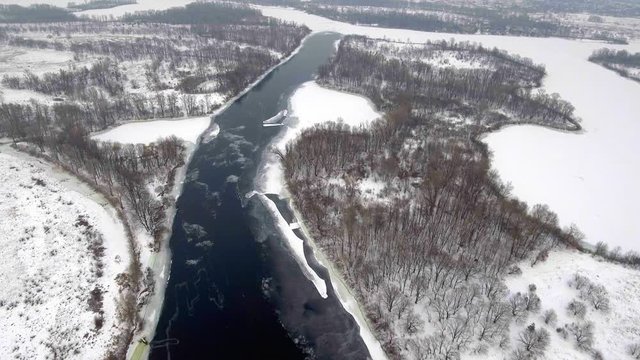 Aerial View. Flight over the beautiful winter river and forest. Nature in winter. Landscape panorama. Ukraine
