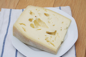 Fetta di formaggio su piatto su tavolo di legno