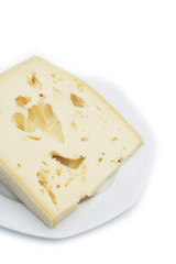 Fetta di formaggio su piatto su sfondo bianco
