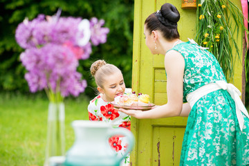 mother with daughter have a breakfast in the garden