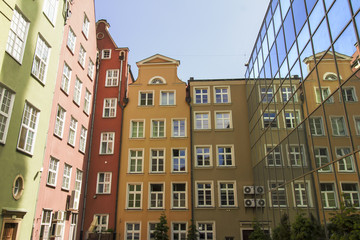 Obraz premium Colorful tenement houses reflected in windows of modern building, Gdansk, Poland