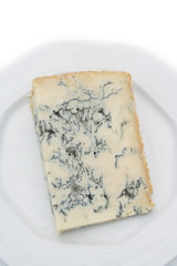 Fetta di gorgonzola su piatto su sfondo bianco