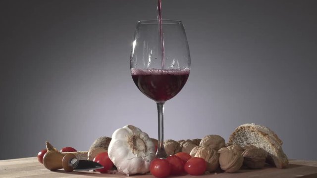 Calice di vino nel mezzo di un tagliere mentre viene riempito