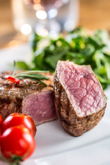 Beef Steak. Juicy beef steak. Gourmet steak with vegetables and glass of rose wine on wooden table.