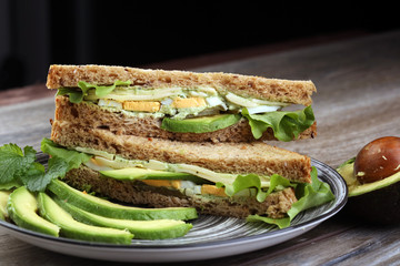 Sandwich with avocado and poached egg - healthy breakfast concep