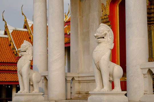 White mythical guard lion in front of the famous marble temple in Wat Benchamabophit in Bangkok ,Thailand