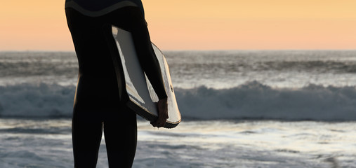 Silhouette surfer bodyboard man on beach at sunset,male body surfer