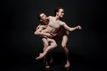 Enthusiastic ballet dancers acting together in the studio