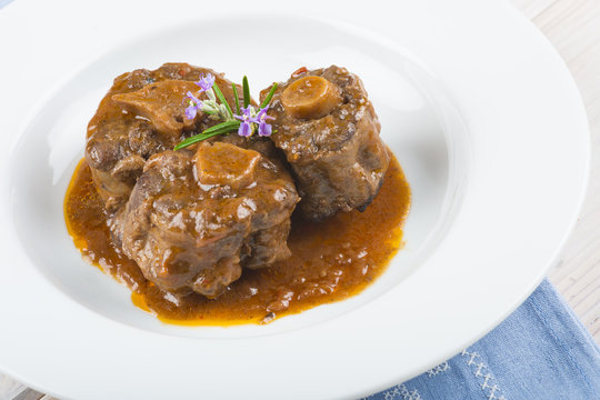 Rabo de toro o ternera en salsa de romero decorado con flores, carne roja para una comida saludable