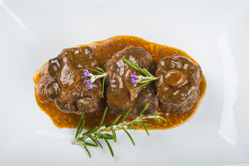 Rabo de toro o ternera en salsa de romero decorado con flores, carne roja para una comida saludable
