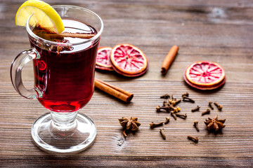 mulled wine with spices in cup on wooden background