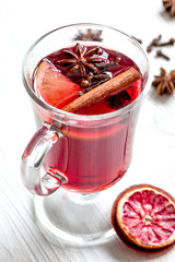 mulled wine with spices in cup on wooden background