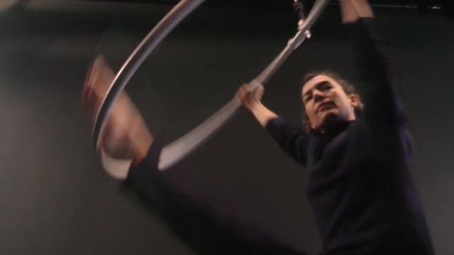 Mujer acr&oacute;bata girando en el aro a&eacute;reo, chica bailarina actuando en el teatro