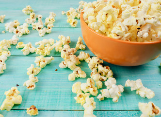Popcorn in cup on blue background.