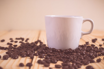 Coffee cup and coffee bean on wood table. vintage color effected