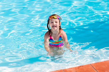Fototapeta na wymiar Child learning to swim in pool