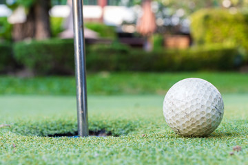 Fototapeta na wymiar Golf ball on green meadow. golf ball near a hole between a golf