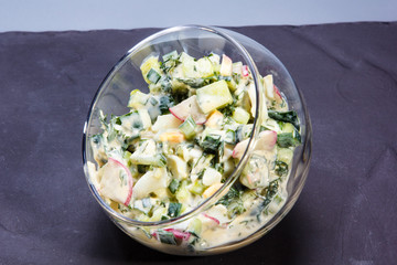 Salad of cucumbers and tomatoes with sour cream in a glass jar.