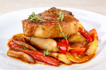 Roast pork with sweet peppers and a sprig of thyme.