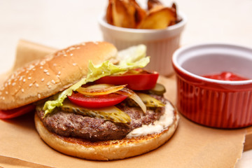Burger with tomato, cucumber, lettuce and grilled onions.