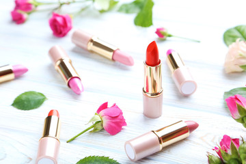Colorful lipsticks on white wooden table