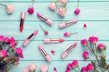 Colorful lipsticks on mint wooden table