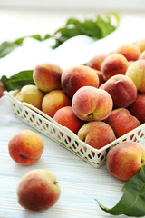 Sweet peach fruit in tray on white wooden table