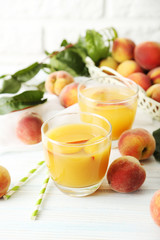 Glasses of peach juice on white wooden table