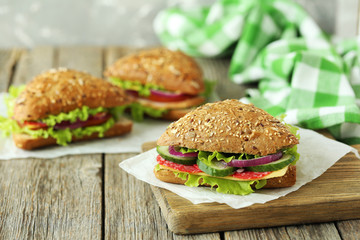 Tasty sandwiches with salami on a grey wooden background