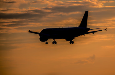 Airplane landing at sunset