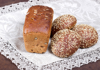 Разный хлеб на льняной салфетке,фон простой.