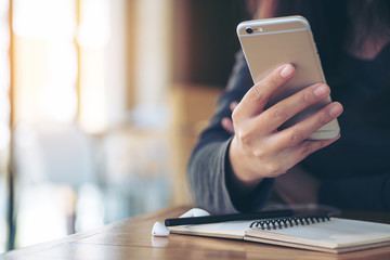A girl using smart phone and sitting in modern cafe