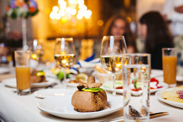 Dessert on plate at served table. Glasses with drinks