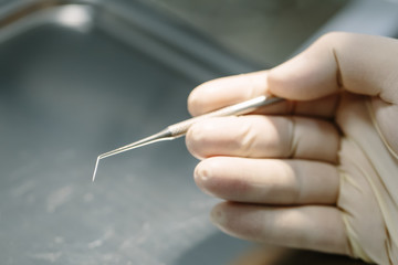 Hand with professional dental tools