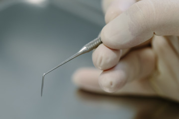Detail of hand holding dental tools in dental clinic. Dentist Co