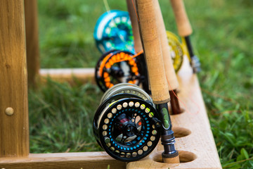 fishing rods with reels for fly fishing on a wooden stand