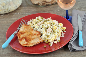 Escalope avec du riz cantonnais dans une assiette avec un verre de rosé