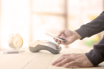 Fototapeta premium Mobile payments concept with EDC machine or credit card terminal with computer laptop and glasses. Warm toning effect.