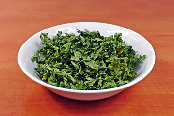 Dried parsley in a white plastic bowl