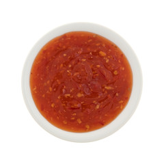Top view of a chili chicken sauce portion in a small bowl isolated on a white background.