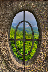 Ausblick auf den Wald durch ein ovales Fenster