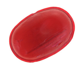 A single menthol cherry flavored cough drop isolated on a white background.